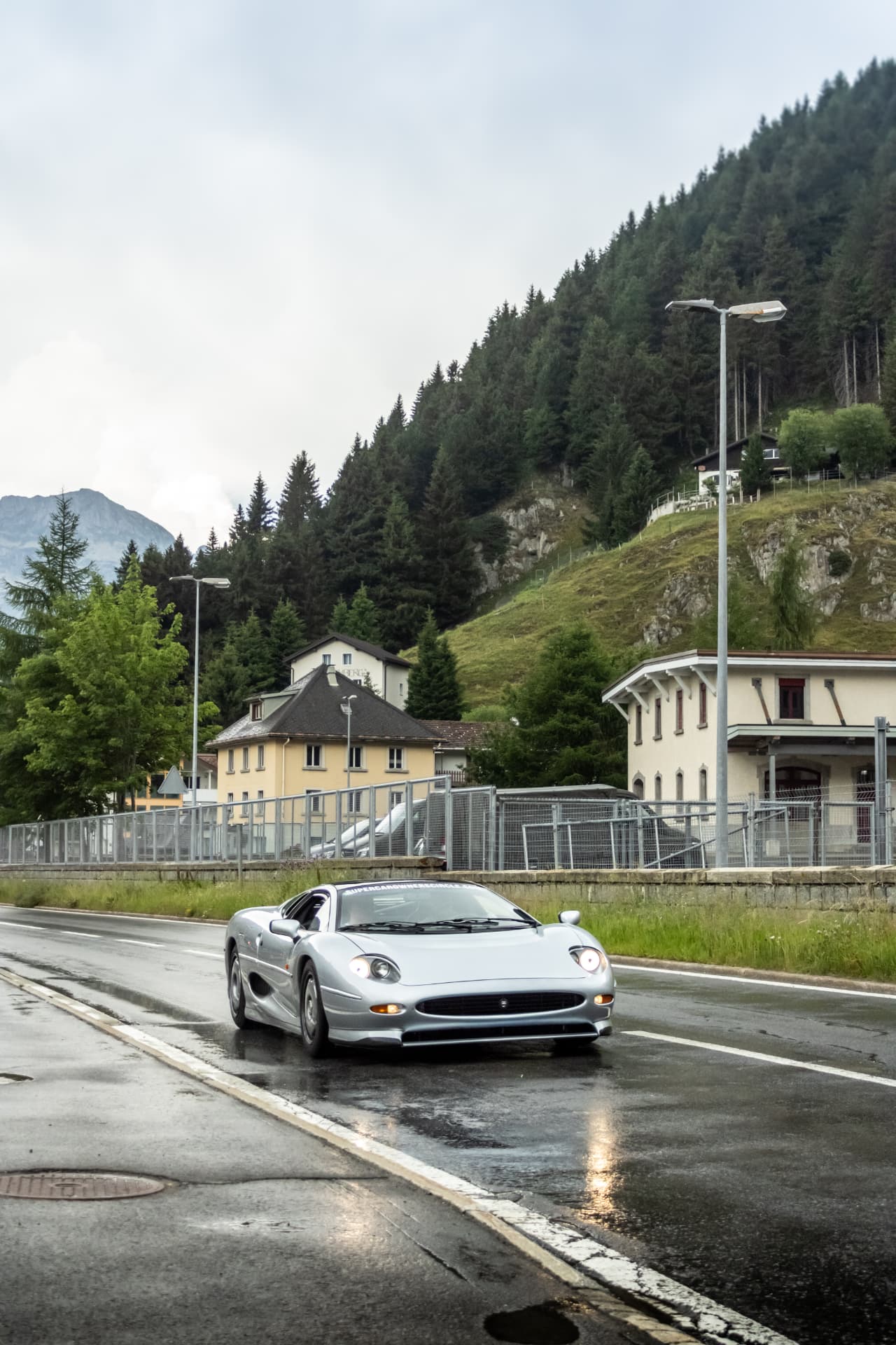 Jaguar XJ220 argentée de face sur route mouillée
