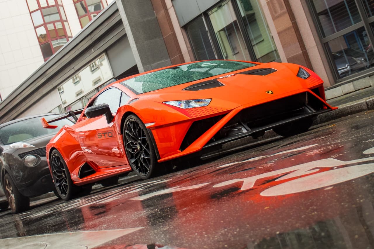 Lamborghini Huracán STO orange en trois-quarts avant sur chaussée mouillée